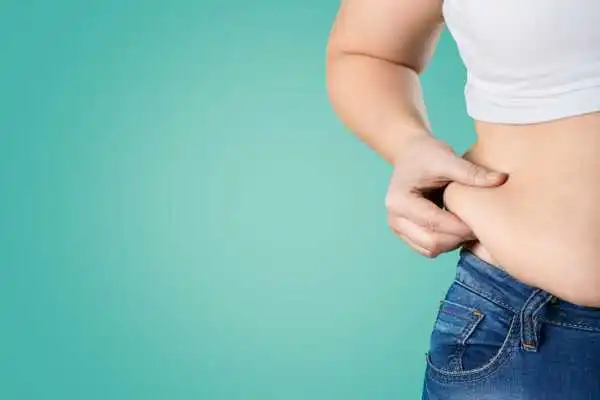 Image of woman pinching her love handles to show weight gain Whitley Bay